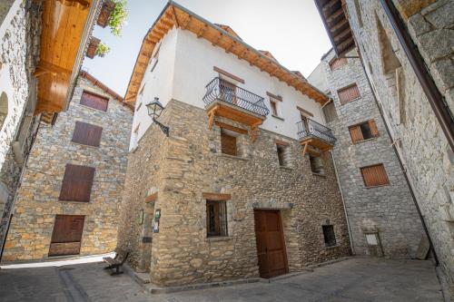 an old stone building with windows and a balcony at Apartamentos Casa Pichuana in Benasque