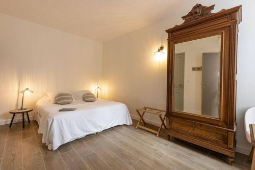 a bedroom with a bed and a large mirror at Le Chat Botté in Saint-Clément-des-Baleines