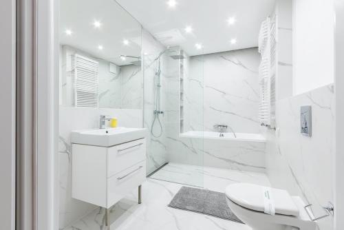 グディニャにあるB&M - By The Sea Apartments Batorego 7の白いバスルーム(シンク、シャワー付)