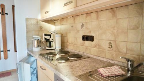 a kitchen with a sink and a stove top oven at Haus Sonnwies in Reit im Winkl