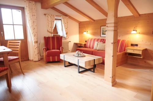 a living room with red chairs and a table at Haus Sonnwies in Reit im Winkl