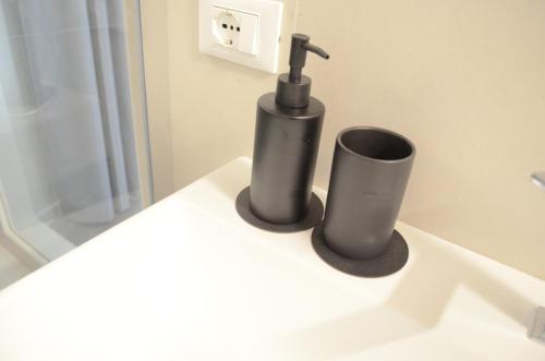a bathroom with a black soap dispenser on a sink at La Casa Incartata in Toscolano Maderno