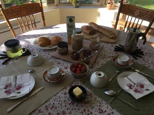 una mesa con un desayuno de cruasanes y comida en ella en Chambre d'hôtes de l'Ancienne école, en RiviÃ¨res