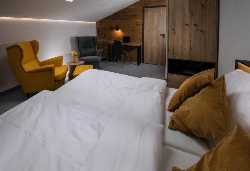 a bedroom with a white bed and a living room at Rooms Svoboda in Olomouc