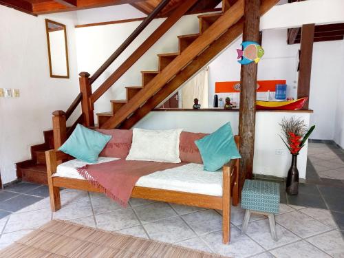 a couch in a living room with a staircase at Villa dos Pássaros Paraty Hospedagem in Paraty