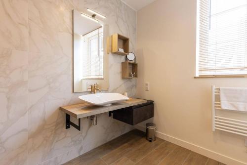 a bathroom with a sink and a mirror at Le Chat Botté in Saint-Clément-des-Baleines