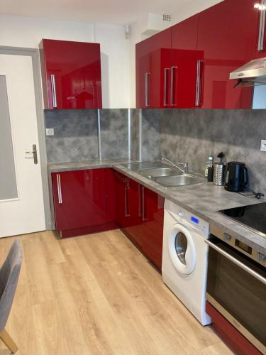- une cuisine avec des placards rouges et un lave-linge dans l'établissement T3 central et paisible à Annecy, à Annecy