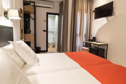 a hotel room with a bed and a bathroom at Hotel Boutique Puerta de las Granadas in Granada