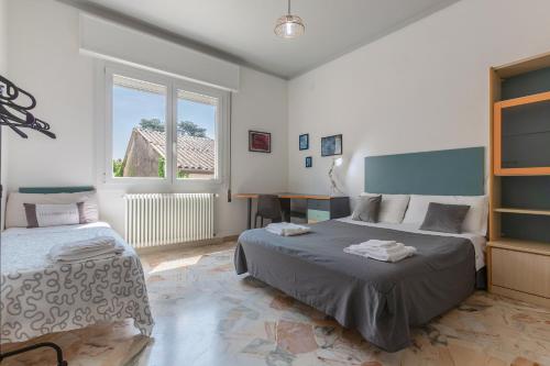 a bedroom with two beds and a window at Cà Licio in Fiesso Umbertiano