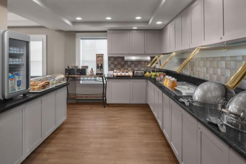 a large kitchen with white cabinets and a counter at Residence Inn Long Island Holtsville in Holtsville