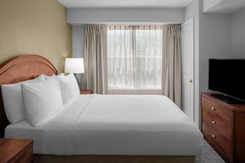 - une chambre avec un grand lit blanc et une fenêtre dans l'établissement Residence Inn Long Island Holtsville, à Holtsville