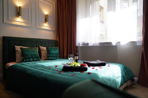 克拉科夫的住宿－Jacuzzi Spa Green Apartment，一间卧室配有带鲜花的绿色床