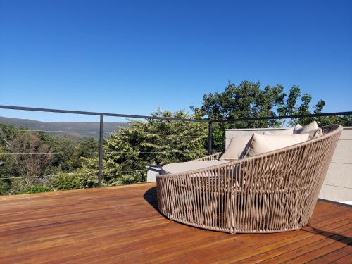 a wicker chair sitting on a wooden deck at Statera Host in Alto Paraíso de Goiás