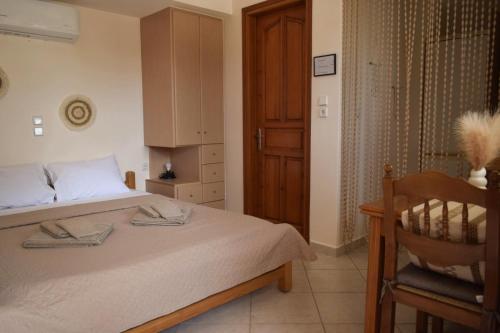 sypialnia z łóżkiem i drewnianymi drzwiami w obiekcie Tranquil Apartments w mieście Naksos