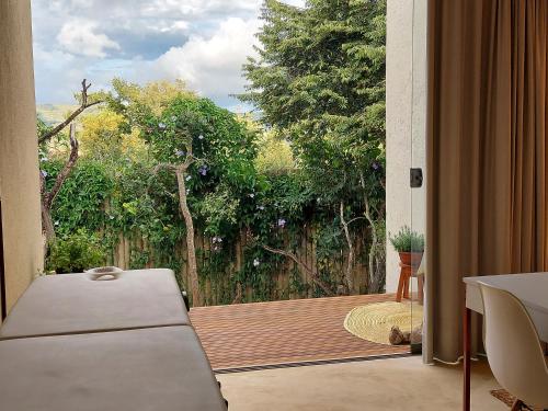 a room with a door open to a deck with trees at Statera Host in Alto Paraíso de Goiás