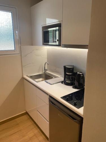 a small kitchen with a sink and a stove at Barbie Hotel Apartments in Ialysos