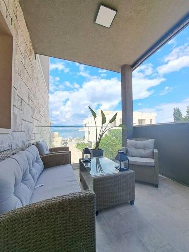 a patio with wicker furniture and a view of the ocean at Daphne Luxe Retreat -Sea View-King size bed- in Supetar