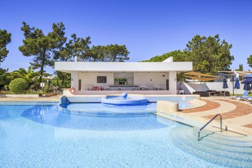 a large swimming pool with a house in the background at Quinta do Lago, Victory Village N 63 in Almancil