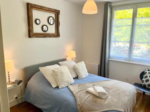een slaapkamer met een bed met twee handdoeken erop bij Joli appartement au cœur de Lisieux avec vue sur la Cathédrale in Lisieux