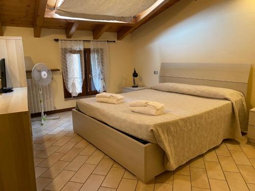 1 dormitorio con 1 cama con 2 toallas en Hotel Adria & Resort en Toscolano Maderno