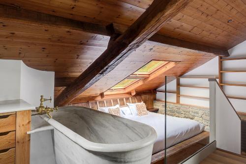 bañera grande en un dormitorio con cama en LIV HOME en Gijón