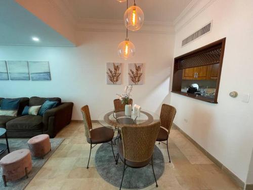 ein Wohnzimmer mit einem Tisch, Stühlen und einem Sofa in der Unterkunft paradisíaco y hermoso apartamento in Santo Domingo