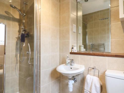 a bathroom with a sink and a shower and a toilet at 23 Brandeston Close in Sudbury