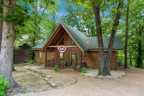 a log cabin in the woods with a flag on it at Dogwood Tree Cabin in Ridgedale