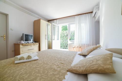 een slaapkamer met een groot bed en handdoeken bij Cozy Studio Near Beach in Baška