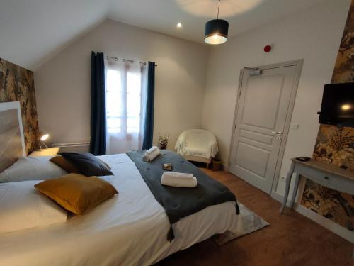 Coutansouze的住宿－Auberge des Colettes，一间卧室配有一张大床和两条毛巾