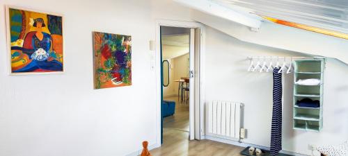 a white hallway with a staircase with a painting on the wall at Maison des Chênes 64 - Independant apartment with terrasse in Boucau