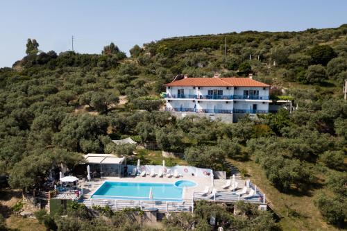 a large house on a hill with a swimming pool at Assa Inn in Pyrgadikia