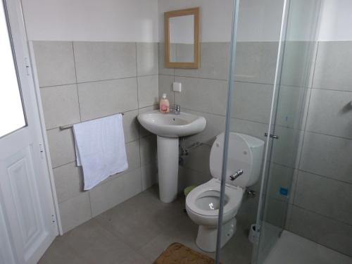 a bathroom with a toilet and a sink at Casa da Lavadia in Canto da Areia