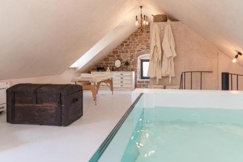 an attic room with a swimming pool and a table at She House - built for pleasure - Island of Brač in Gornji Humac