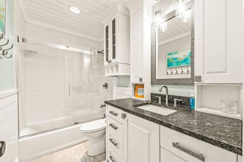 a white bathroom with a sink and a toilet at Foley Palms & OWA Resort / Pool in Foley