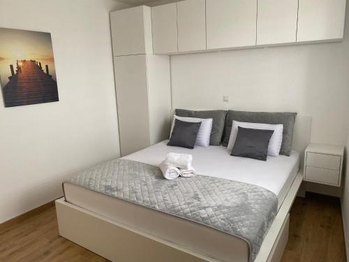 una camera da letto con un grande letto e pareti bianche di Wellness Apartments Sunset a Zara (Zadar)