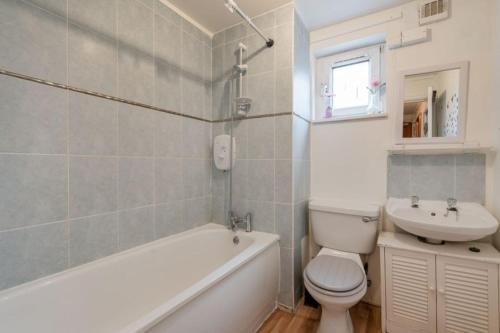 a bathroom with a tub and a toilet and a sink at Entire City Center Cozy Flat in Edinburgh
