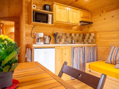Ce chalet en bois comprend une cuisine et une table à manger. dans l'établissement Gites et Roulottes au Domaine de la Trille, à Sainte-Foi