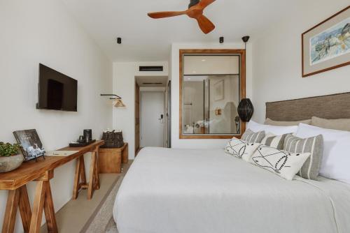 a bedroom with a white bed and a ceiling fan at Casa Manor Boutique Hotel in Tivat