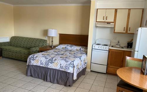 a small room with a bed and a kitchen at Ocean Cove Motel in Virginia Beach