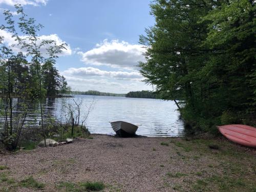 a boat sitting on the shore of a lake at Joarsbo, Stuga 3, Klinten in Kalv