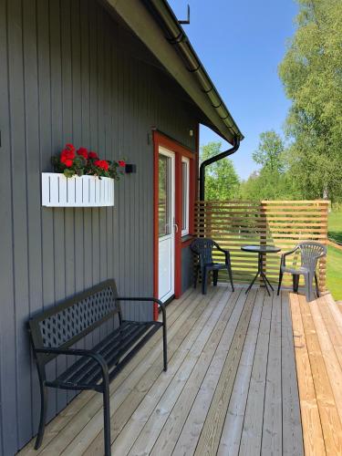a porch with benches and a table on a house at Joarsbo, Stuga 3, Klinten in Kalv
