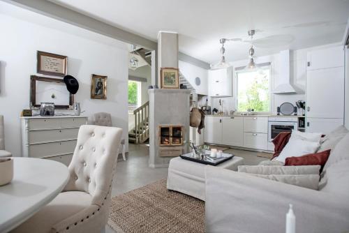 Sala de estar blanca con sofá y mesa en Villa Vivante, en Porvoo