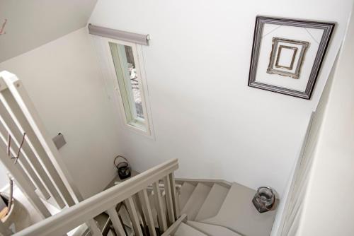 a white staircase with a picture on the wall at Villa Vivante in Porvoo