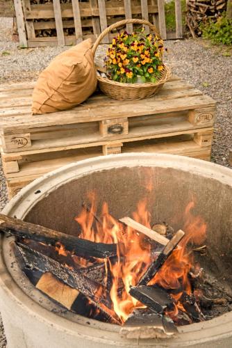 a fire in a pot with a grill and a basket of flowers at Villa Vivante in Porvoo