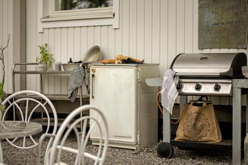 einen Grill und einen Tisch mit Stühlen und einem Tisch mit einem Tisch in der Unterkunft Villa Vivante in Porvoo