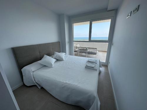 Schlafzimmer mit einem Bett und Meerblick in der Unterkunft LUXURY Apartaments Gran Canet in Canet d'en Berenguer