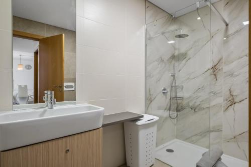 a white bathroom with a sink and a shower at Cote D Atlantique by Homie in Caniço