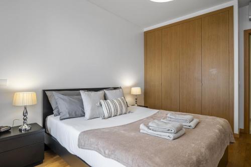 a bedroom with a large bed with towels on it at Cote D Atlantique by Homie in Caniço