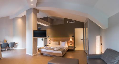Vrnjačka BanjaにあるEmilia Lux Roomsのベッドとテレビ付きのホテルルーム